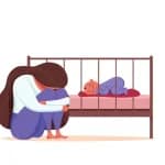 baby blues – sad and exhausted mother sitting beside a sleeping baby in a crib