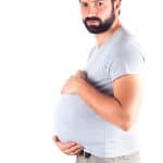 couvade syndrome man holding his belly mimicking pregnancy symptoms