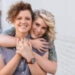 Lesbian couple baby options smiling couple embracing and looking happy together