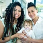 portrait lesbian couple sitting their baby
