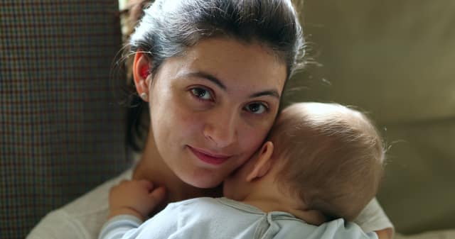 Having a baby alone single mother holding her baby with a loving expression