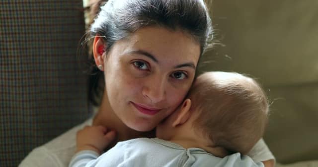 Having a baby alone single mother holding her baby with a loving expression