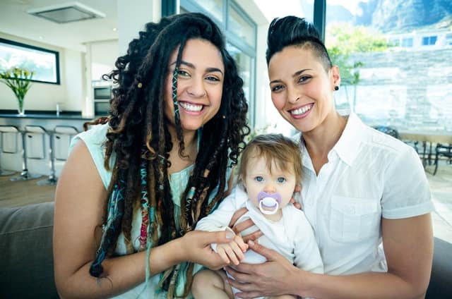 portrait lesbian couple sitting their baby