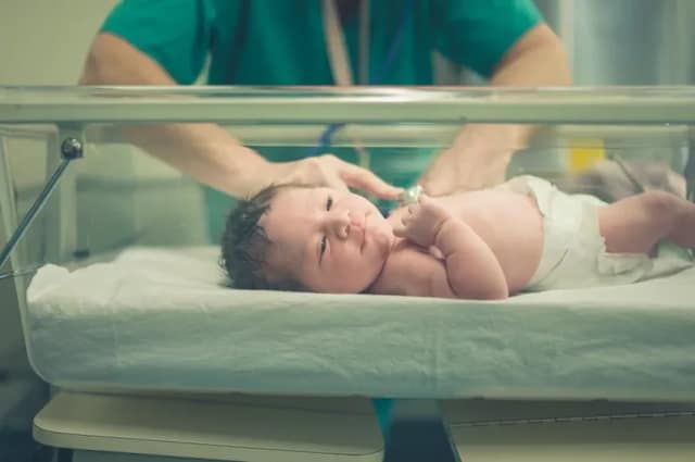 three parent baby concept showing newborn in hospital after advanced reproductive procedure