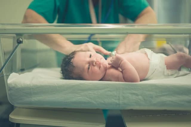 three parent baby concept showing newborn in hospital after advanced reproductive procedure