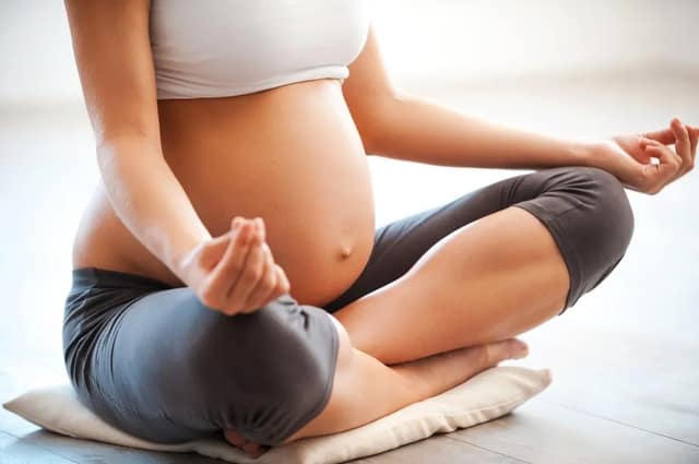 pregnancy exercise with a pregnant woman practicing yoga and meditation