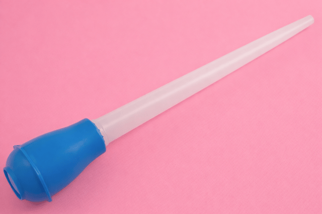 Home insemination kit with syringe on pink background