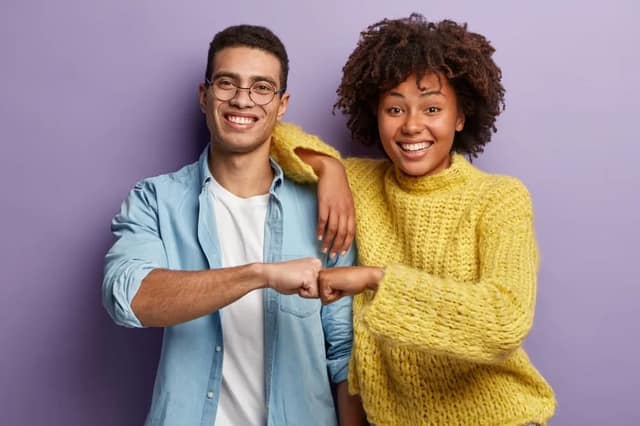 co parenting relationship – smiling man and woman giving a fist bump showing teamwork and agreement