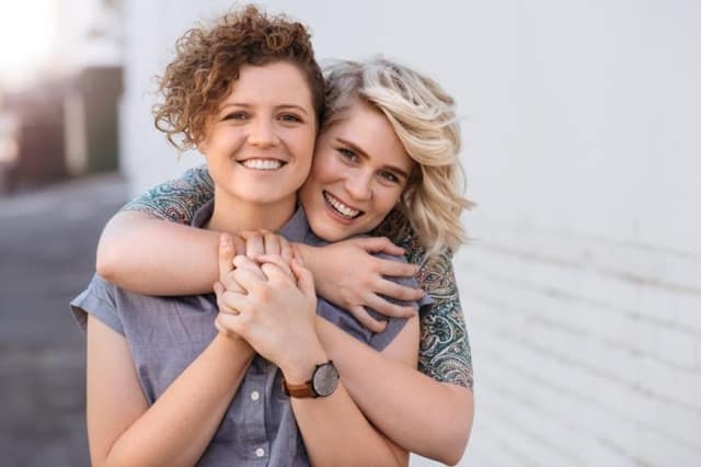 Lesbian couple baby options smiling couple embracing and looking happy together