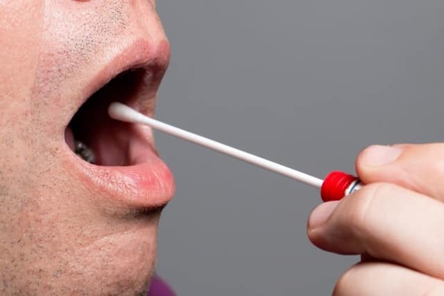 Genetic testing sperm donors man providing a saliva sample with a swab for DNA analysis