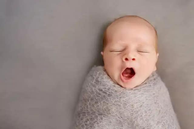 Donor conceived baby bonding newborn baby yawning in close-up during early bonding moment