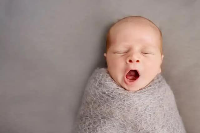 Donor conceived baby bonding newborn baby yawning in close-up during early bonding moment