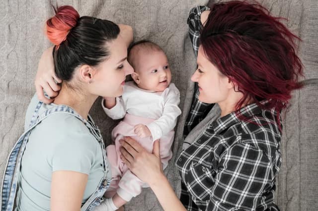 two young women casual clothes with a baby