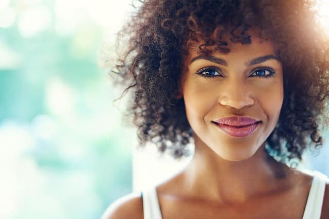 portrait smiling young black woman sunlight