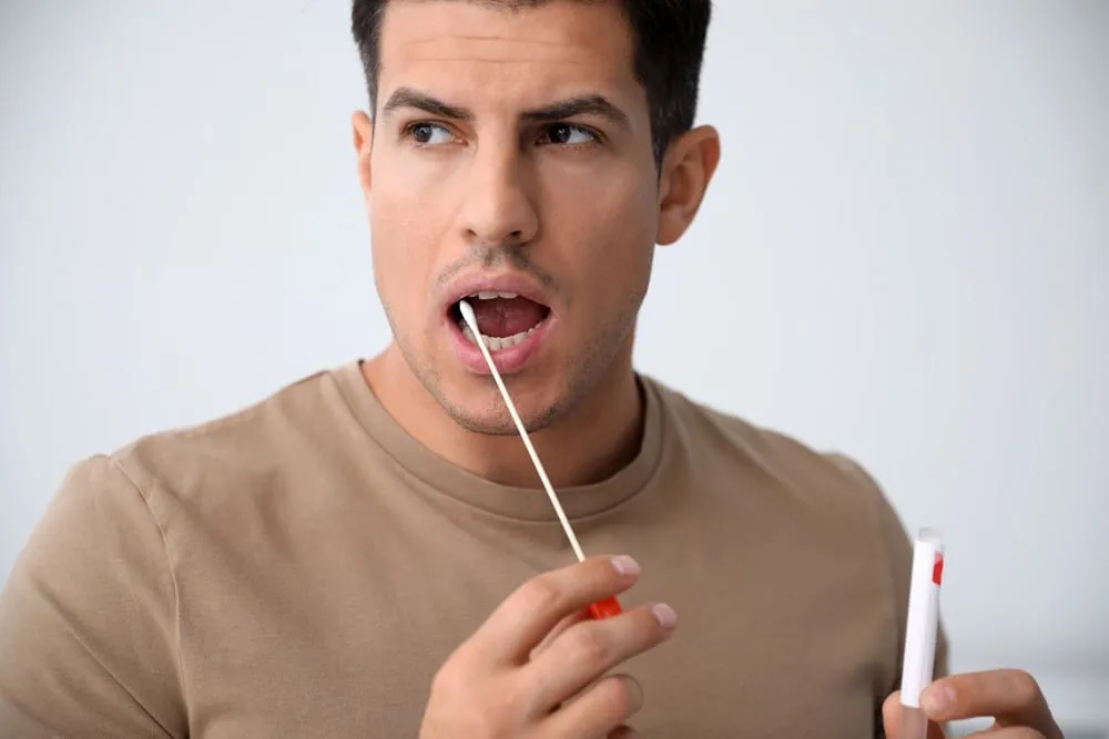paternity test – man collecting a DNA sample with a cheek swab for testing