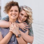 Lesbian couple baby options smiling couple embracing and looking happy together