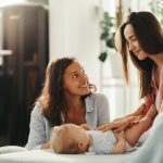 Homoparental family two women caring for a baby together at home